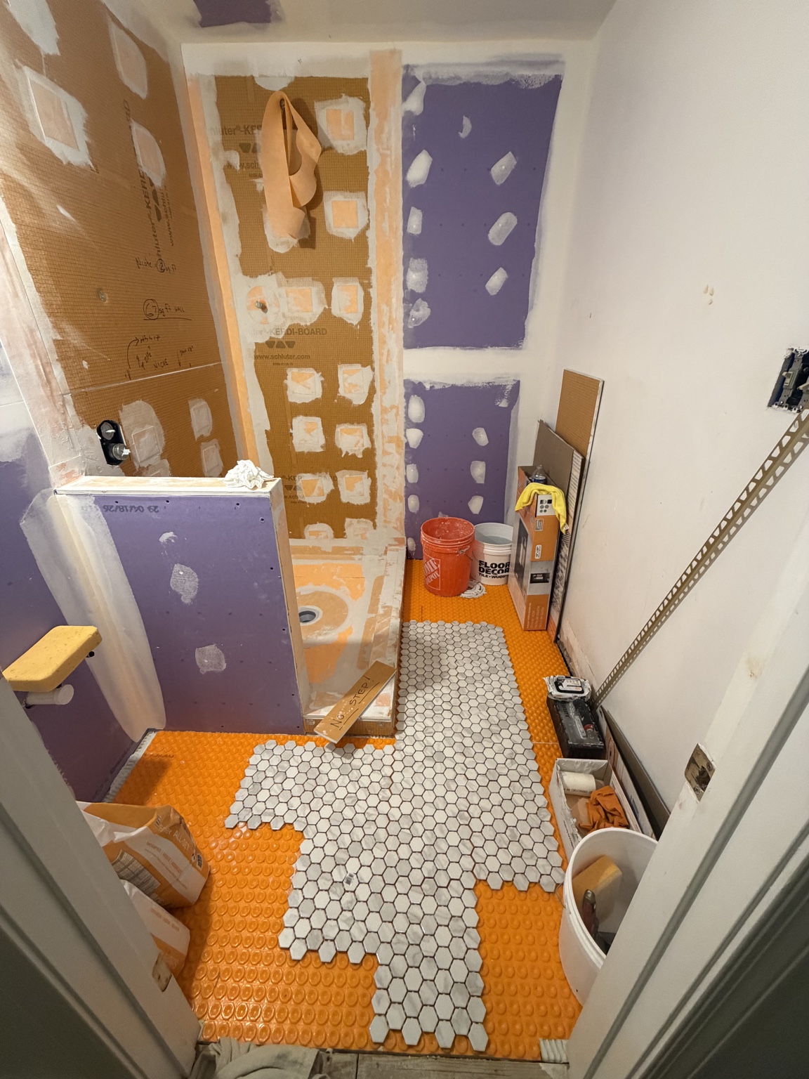 Lowered bathroom floor waterproofed and ready for hex tile installation